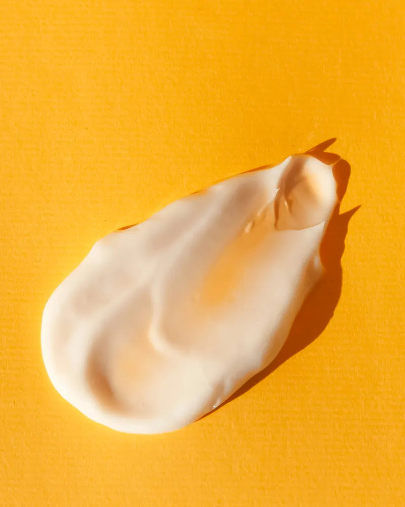 A swirl of thick white cream on a warm yellow background