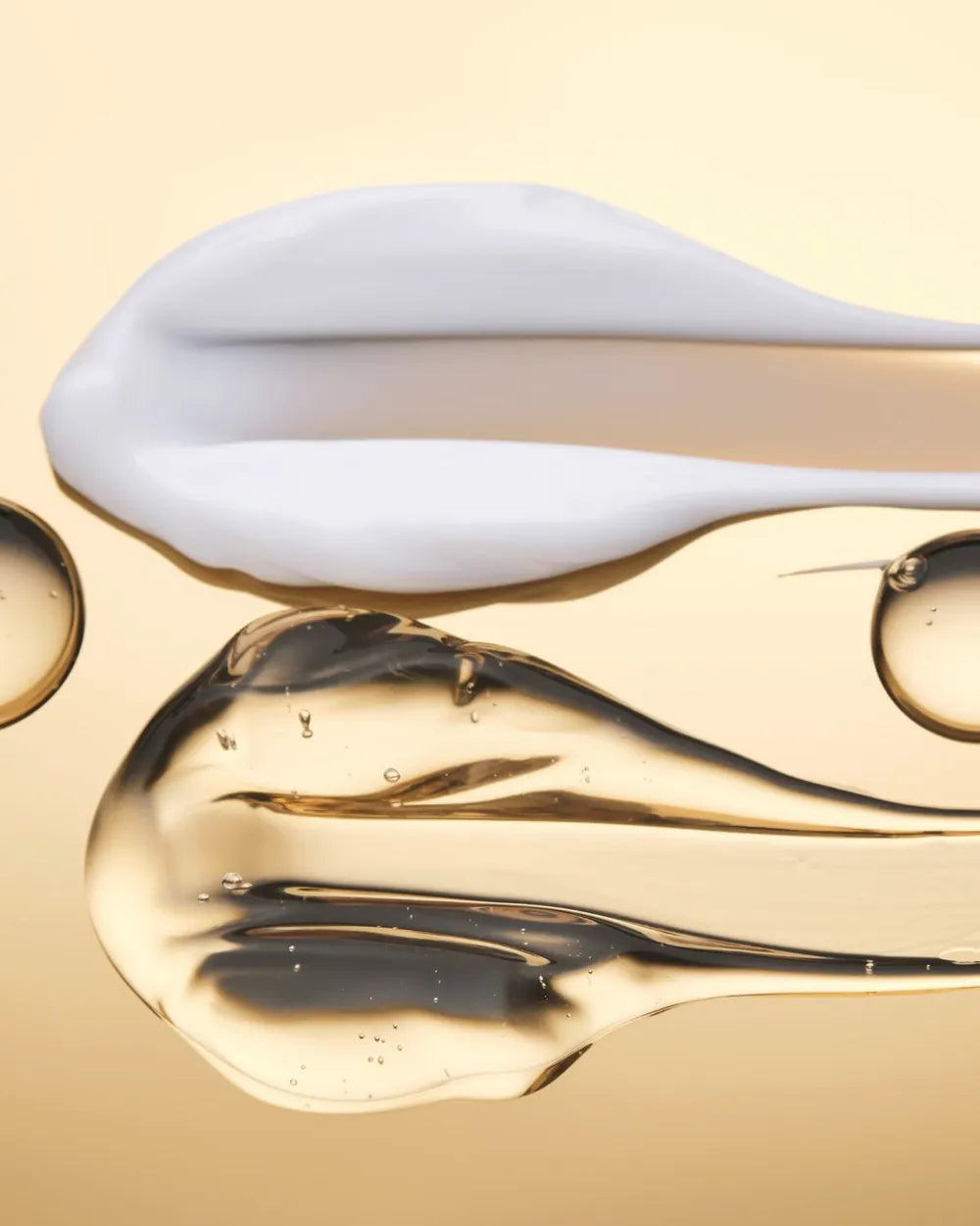 A swipe of cream beside clear drops of glycerin